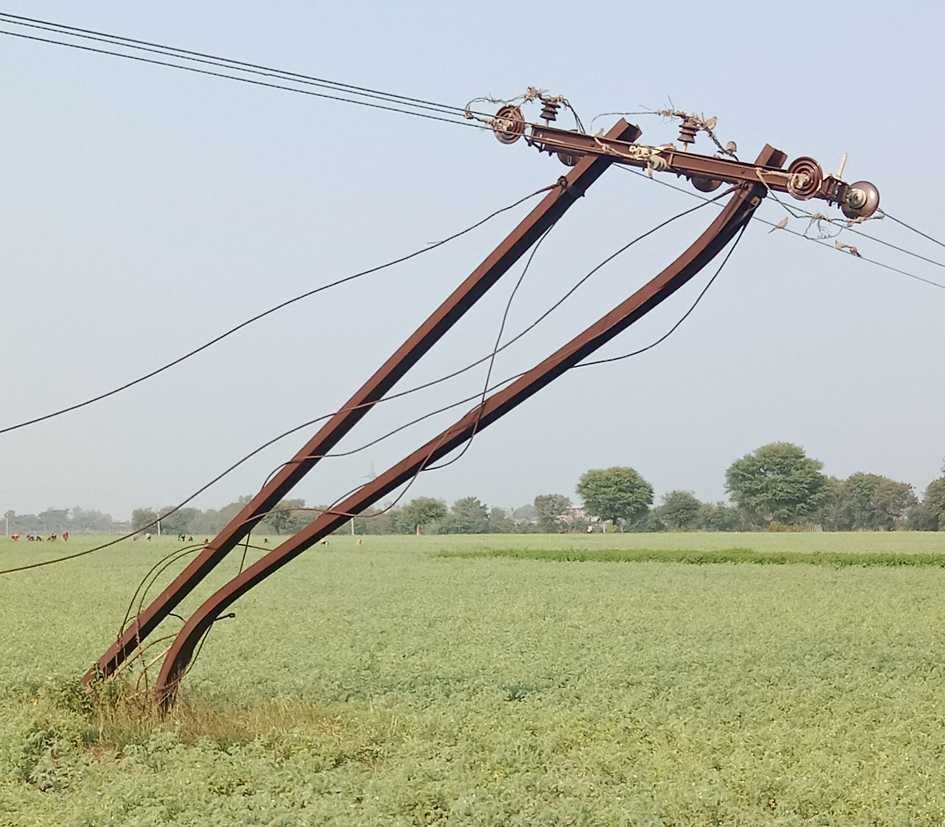विडंबना….  वाहनों की टक्कर से तिरछे हुए पोल, झूल रही केबल